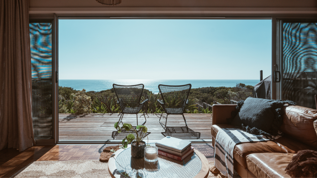 Grand intérieur d'une maison avec fenêtre ouverte, vue sur l'horizon, deux chaises côte à côte