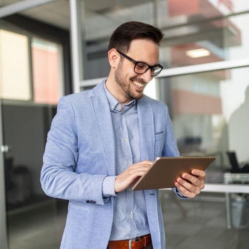 Smiling business man using digital tablet in the office Smiling young business man using digital tablet in the office